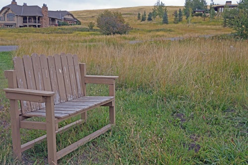 Bench on hill with homes in background